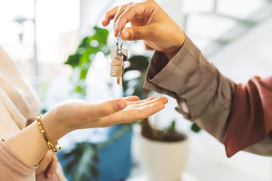 Realtor giving house key to woman