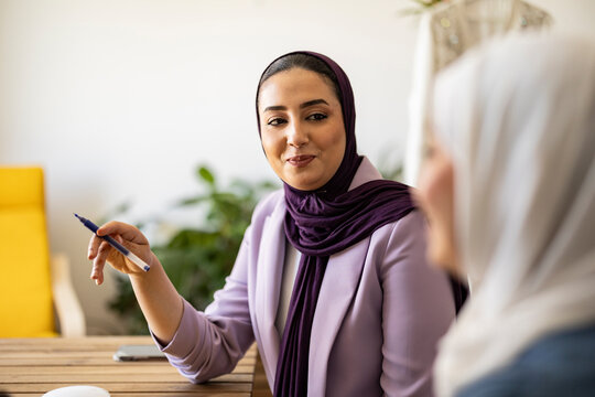 Smiling wedding planner having discussion with colleague
