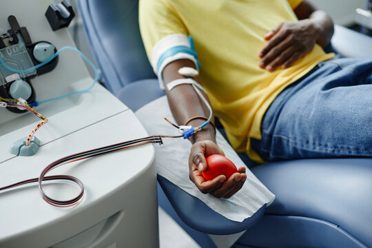Man holding soft ball and donating blood at center