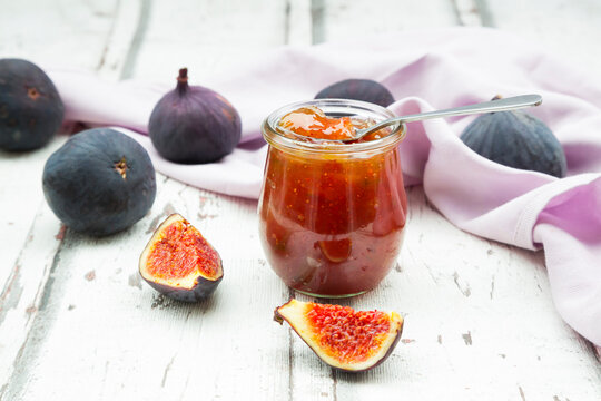 Organic figs and a glass of fig jam on a wood