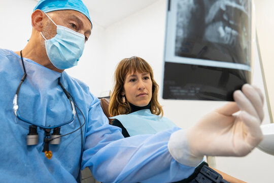 Dentist showing x-ray image to patient at clinic