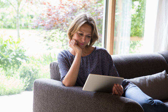 Woman using digital tablet on couch
