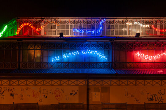 Torino, Italia - 13/12/2014 - Porta Palazzo. Facciata con insegne al neon multilingue su struttura metallica. Scena urbana notturna ideale per arte pubblica, diversit&agrave; culturale e comunicazione.