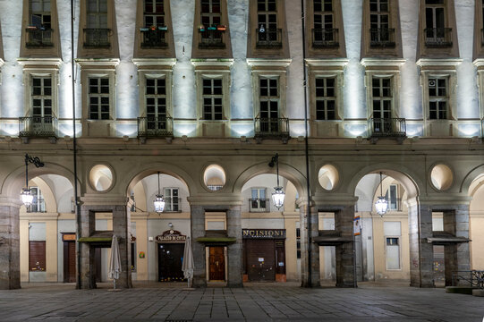 Torino, Italia - 13/12/2014 - piazza Palazzo di Citt&agrave;. Portici storici illuminati con colonne e negozi chiusi in scena notturna urbana, ideale per temi architettura, eleganza e citt&agrave;.