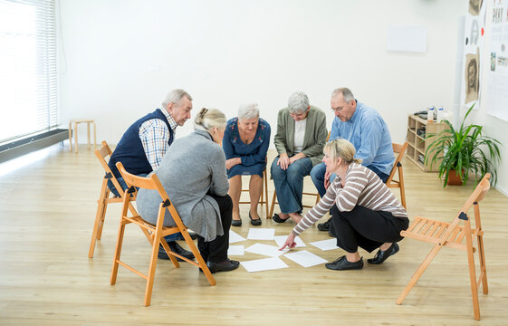Group of seniors in retirement home evaluating result of group therapy