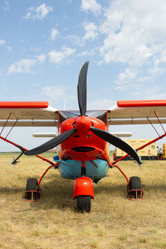 Front View of Small Agricultural Propeller Aircraft Standing on Field
