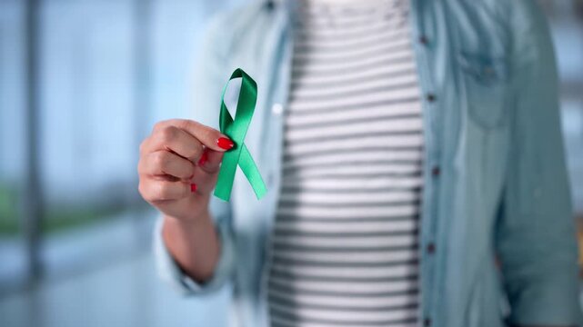 Woman Holds A Teal Ribbon In Her Palm