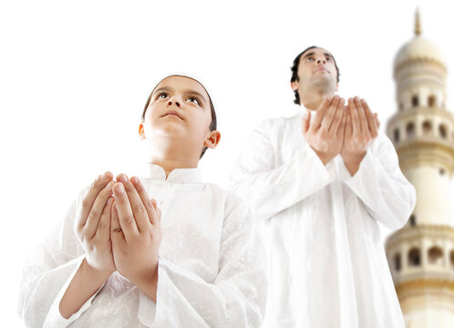 Muslim man and his son praying