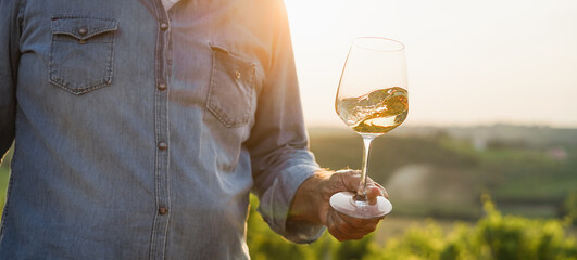 Wine producer mane tasting the product after harvest and grape fermentation process - Vinification, organic quality product and small business concept - Main focus on glass © DisobeyArt