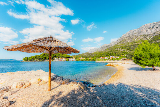 Stunning pebble beach in Drvenik with crystal clear turquoise water and the Biokovo mountain in the Makarska Riviera, Croatia.
