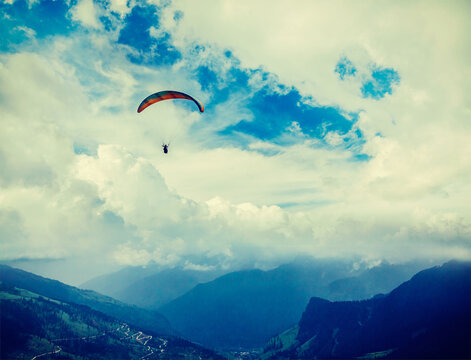 Vintage retro effect filtered hipster style travel view of freedom flight concept - paraplane in sky over Himalayas mountains