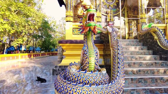 Golden Naga holy snake dragon statue in front of Buddhist temple in Thailand decorated stairs