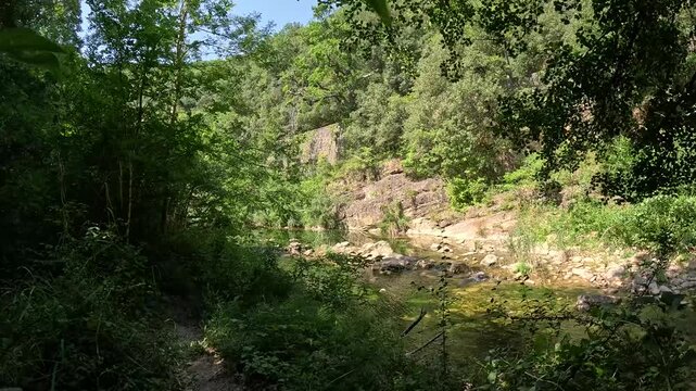 POV walking on forest hiking trail beside river, France