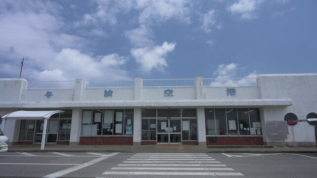 青空と白い雲の下に建つ与論空港のターミナルビル