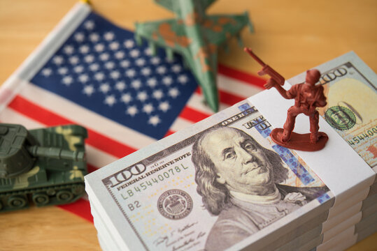 US banknotes, army solider, combat aircraft fighter, tank on American flag. U.S. military spending or defense budget, research and development, maintenance, procurement, peacekeeping and so on concept