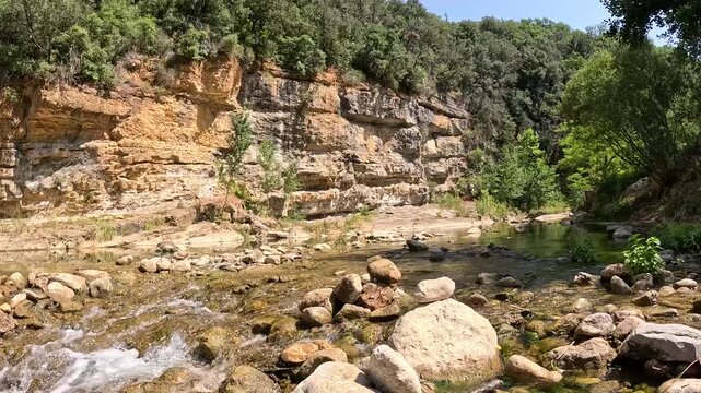 Rocky river flowing beneath limestone cliffs in Rennes-les-Bains France
