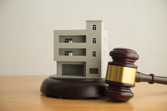 Commercial building and gavel judge in courtroom with white wall background. Asset forfeiture, foreclosure, repossession procedure in court, law enforcement, bankruptcy, money laundering, law concept.