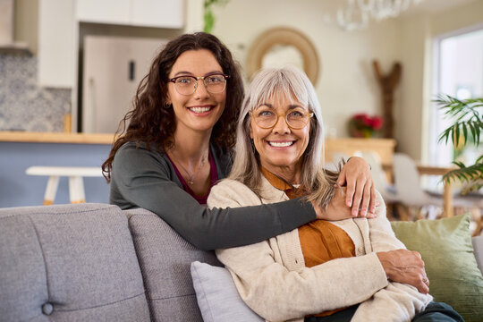 Portrait of smiling daughter embracing old mother while wearing eyeglasses
