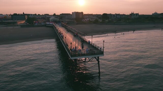 Coastal sunset seaside holiday resort of Skegness on the east coast of Lincolnshire UK, English vacation and sweeping vista views. Evening nightlife with Big Wheel rides and amusements. Pier and town