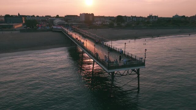 Coastal sunset seaside holiday resort of Skegness on the east coast of Lincolnshire UK, English vacation and sweeping vista views. Evening nightlife with Big Wheel rides and amusements. Pier and town