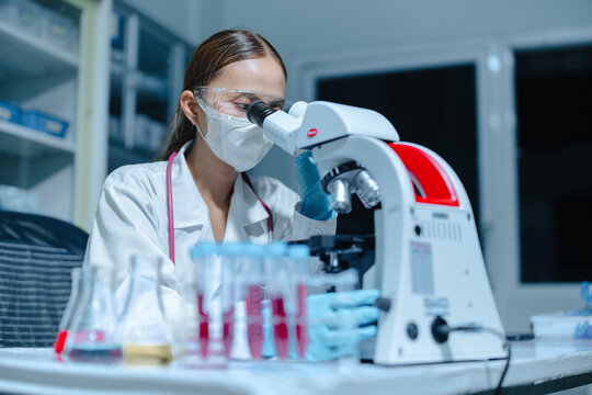 Clinical Laboratory Scientist Looking Through Microscope During Biomedical Medical Research