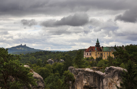 Scenic view of an old medieval castle rising above sandstone rocks and a green forest in Bohemian Paradise, Czech Republic