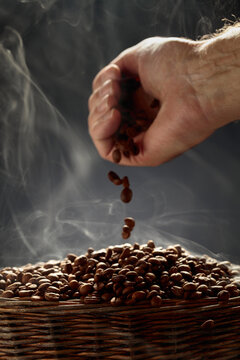 The freshly roasted coffee beans are poured into a basket.