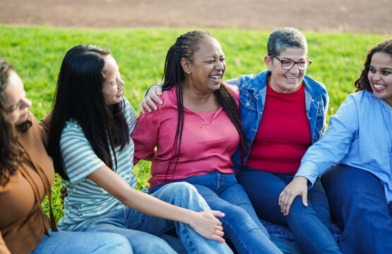 Happy multiracial women with different age having fun together at city park - Multi generational female friendship concept