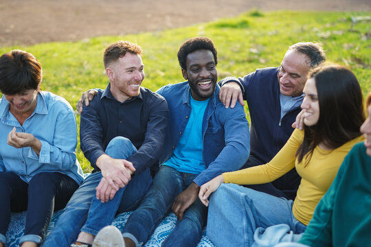 Happy multiracial people with different age having fun together at city park - Multi generational group, community and social inclusion concept