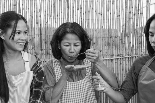 Asian mother and daughter's cooking together traditional thai soup outdoor - Culture, family people and food concept - Black and white editing