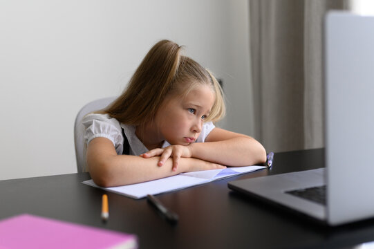 Bored Tired Schoolgirl Lying on Hands near Laptop during Online Distance Education