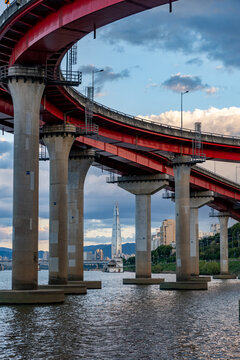 Red bridge structure over Han River with Seoul skyline and Lotte World Tower in background, South Korea