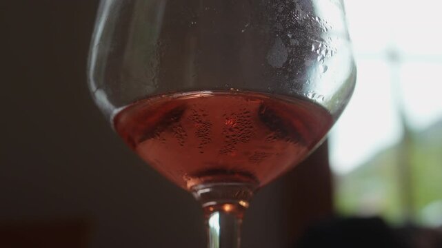 Close up ros&eacute; wine in glass with condensation at restaurant table, highlighting refreshment, elegant dining, hospitality and gourmet lifestyle