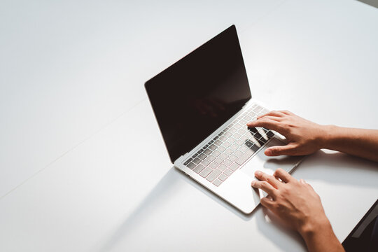 Person's hands typing on laptop computer keyboard, working remotely, browsing internet, connecting online, focusing on digital tasks and modern technology