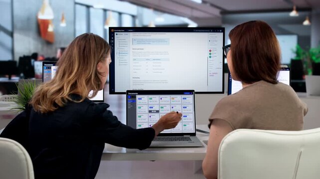 Two Women Use Laptops