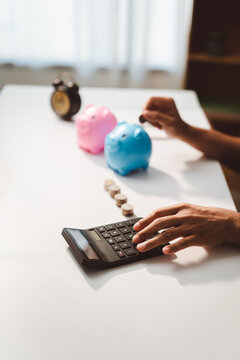 Person saving coin into piggy bank while calculating finances, planning for future wealth and managing budget, responsible investment and financial growth concept