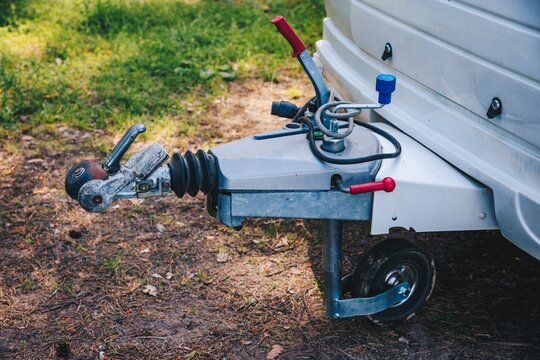 Trailer hitch coupling mechanism with locking system and safety features on grassy ground