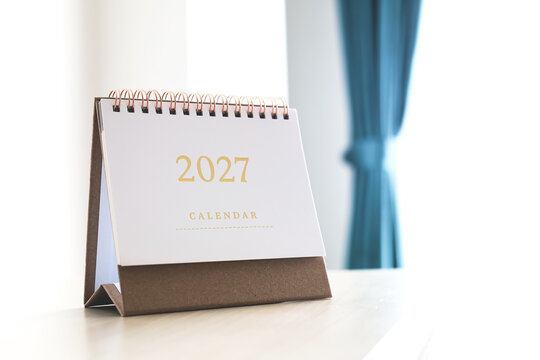 2027 desk calendar with gold numbers on craft paper base. Concept of new year resolution, annual planning, and time management.