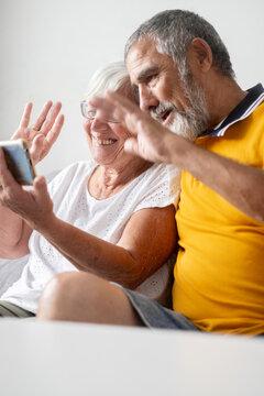 Senior couple waving during video call