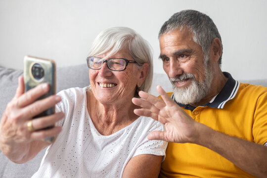 Senior couple waving during video call