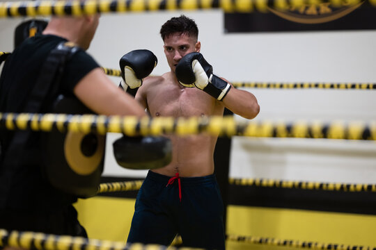 Boxer Sparring With Coach In Gym Ring During Intense Training Session For Fight Preparation