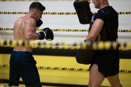 Boxing Training Session With Athlete Sparring Pads And Coach In A Gym Ring