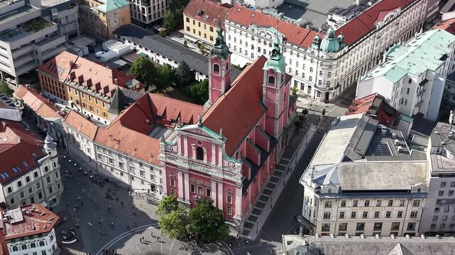 Flight over pink Franciscan Church of the Annunciation in Ljubljana, Slovenia