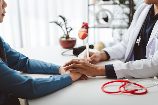 Doctor consoling patient at clinic desk, showing empathy and support during a medical consultation, building trust and offering reassurance for well-being