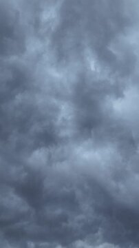 Ominous dark storm clouds rolling through the sky, creating a dramatic and foreboding atmosphere as they move quickly, covering the view with their turbulent and moody gray texture