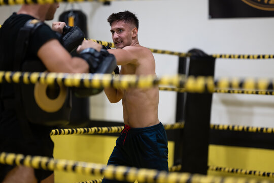 Young Boxer Sparring With Trainer in Gym Ring During Intense Boxing Training Session