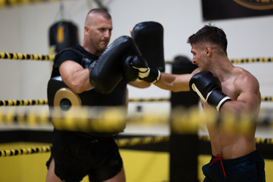 Young Boxer Training With Coach in Boxing Ring During Intense Sparring Session