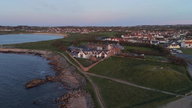 Grandes Rocques Guernsey.Forward,drone footage of hotel and apartment complex with views over bays,beaches and coast road in late afternoon sun on a clear day with a pink tinge to the sky