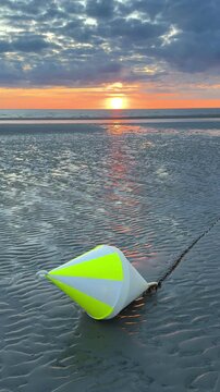 buoy in sunset light on the beach