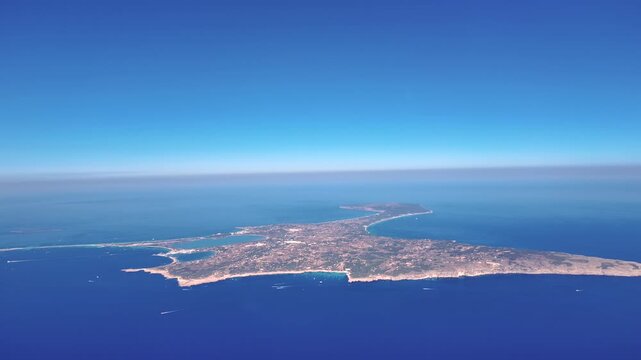 Aerial spinning view of Formentera island taken from a jet cockpit in a bright summer morining in a deep blue color Mediterranean sea. 4K shot.